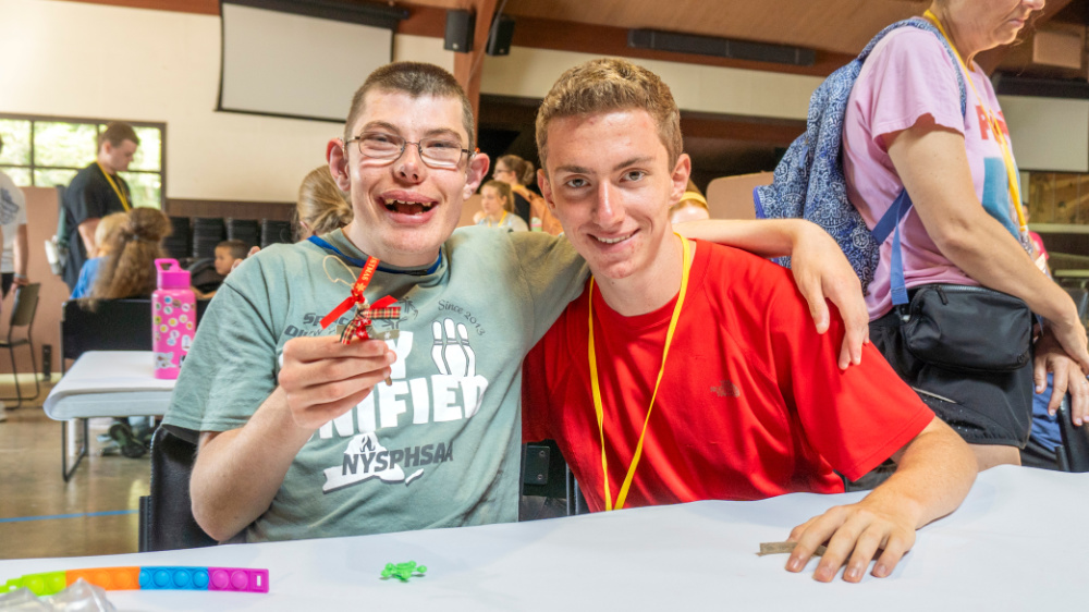 A camper and volunteer pose for a photo