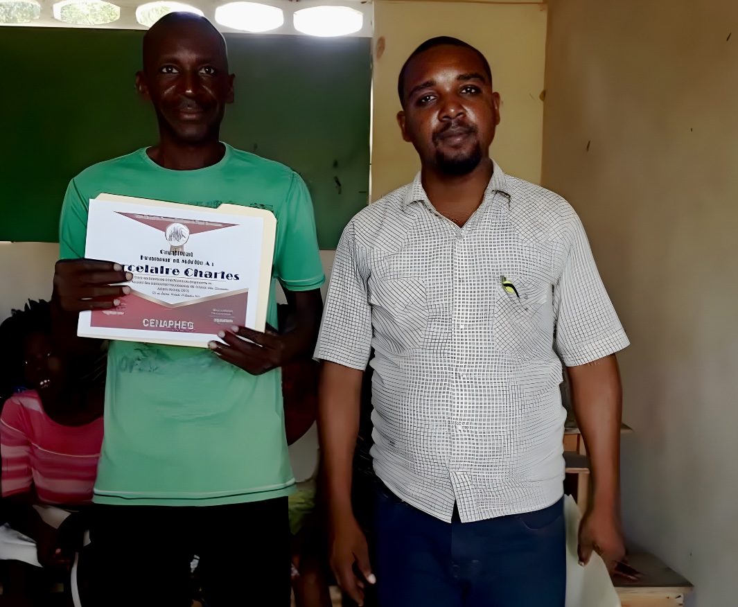 Alfreno next to a Motorbike taxi driver. Both are smiling for the camera.