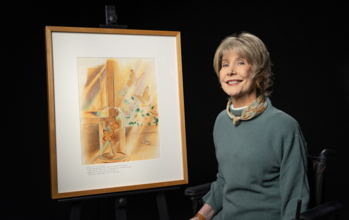 Joni Eareckson Tada sits beside her painting Through a Glass Darkly, which depicts butterflies inside a glass dome and others flying outside a window.