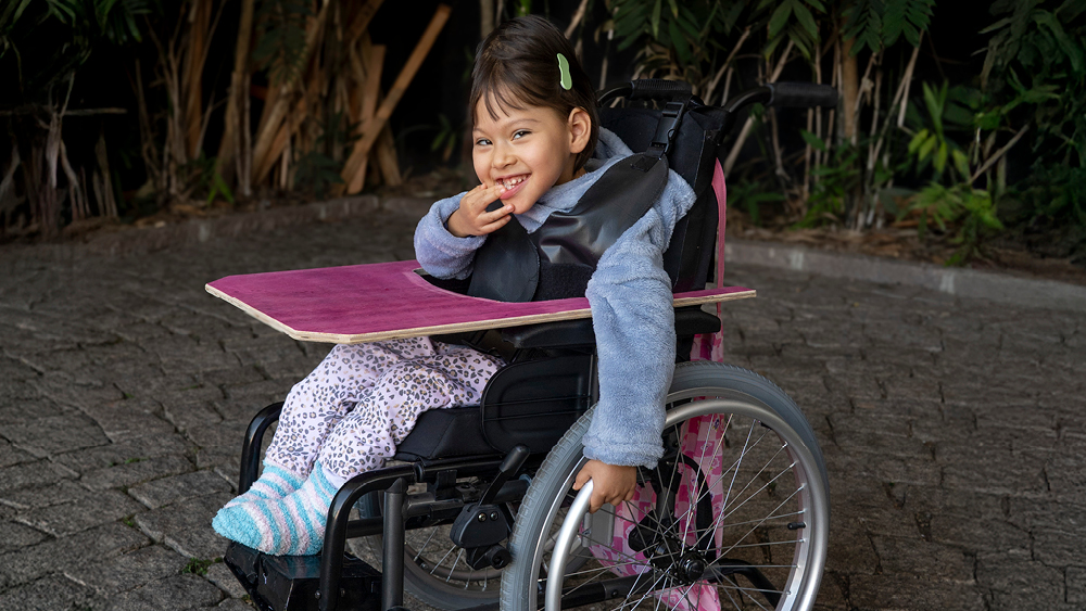 A girl smiles in her new wheelchair