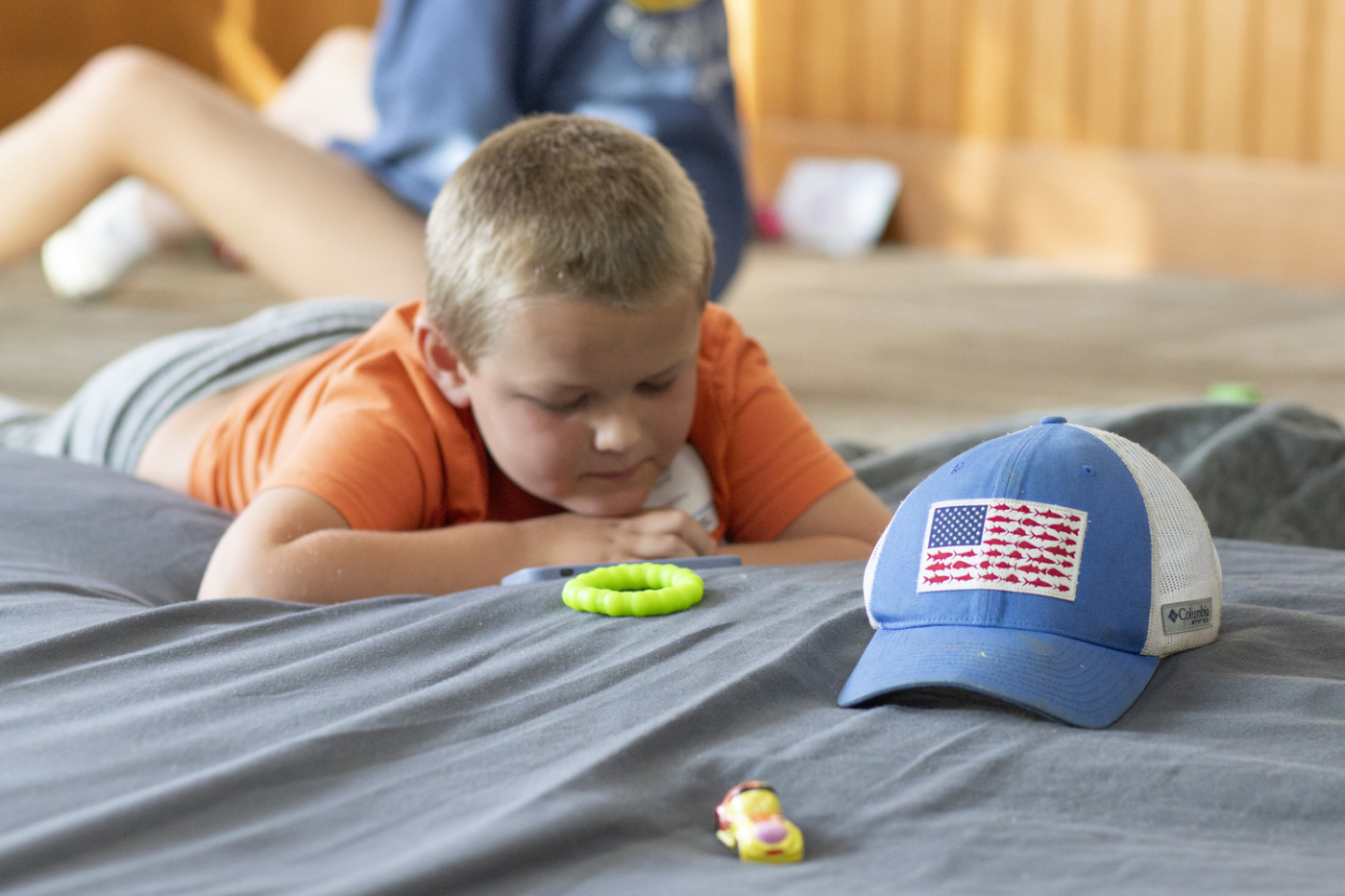 Wyatt lying on his stomach, looking at a phone.