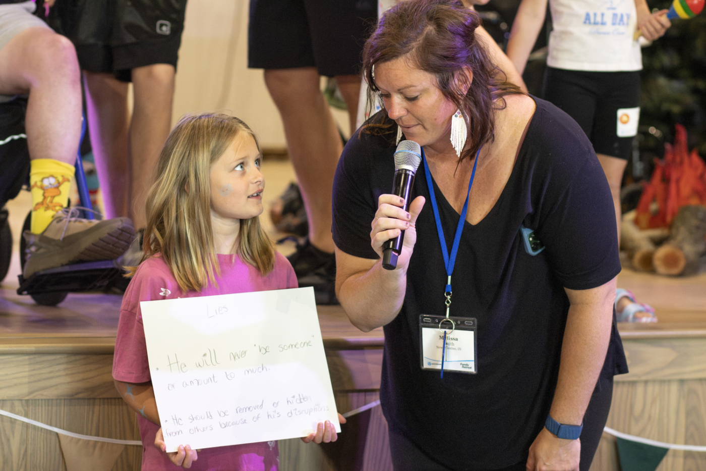 Wyatt's sister looking at a woman holding a microphone.