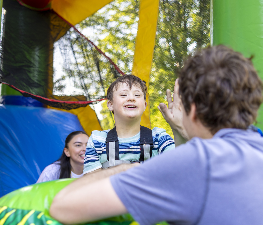 Teddy having fun on a balloon bounce house with a slide.