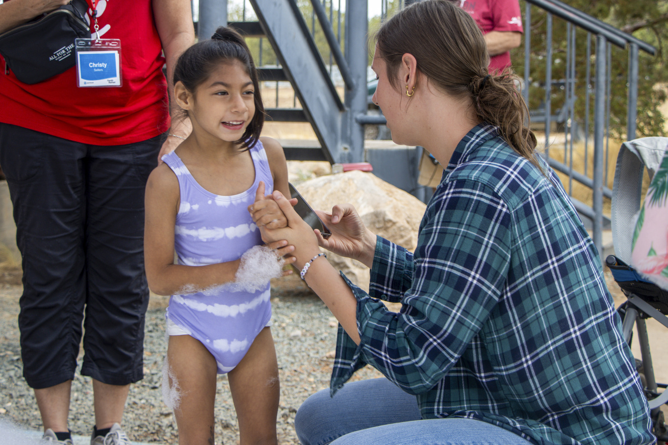 Bella enjoys playing with bubbles while facing her buddy at the Family Retreat.
