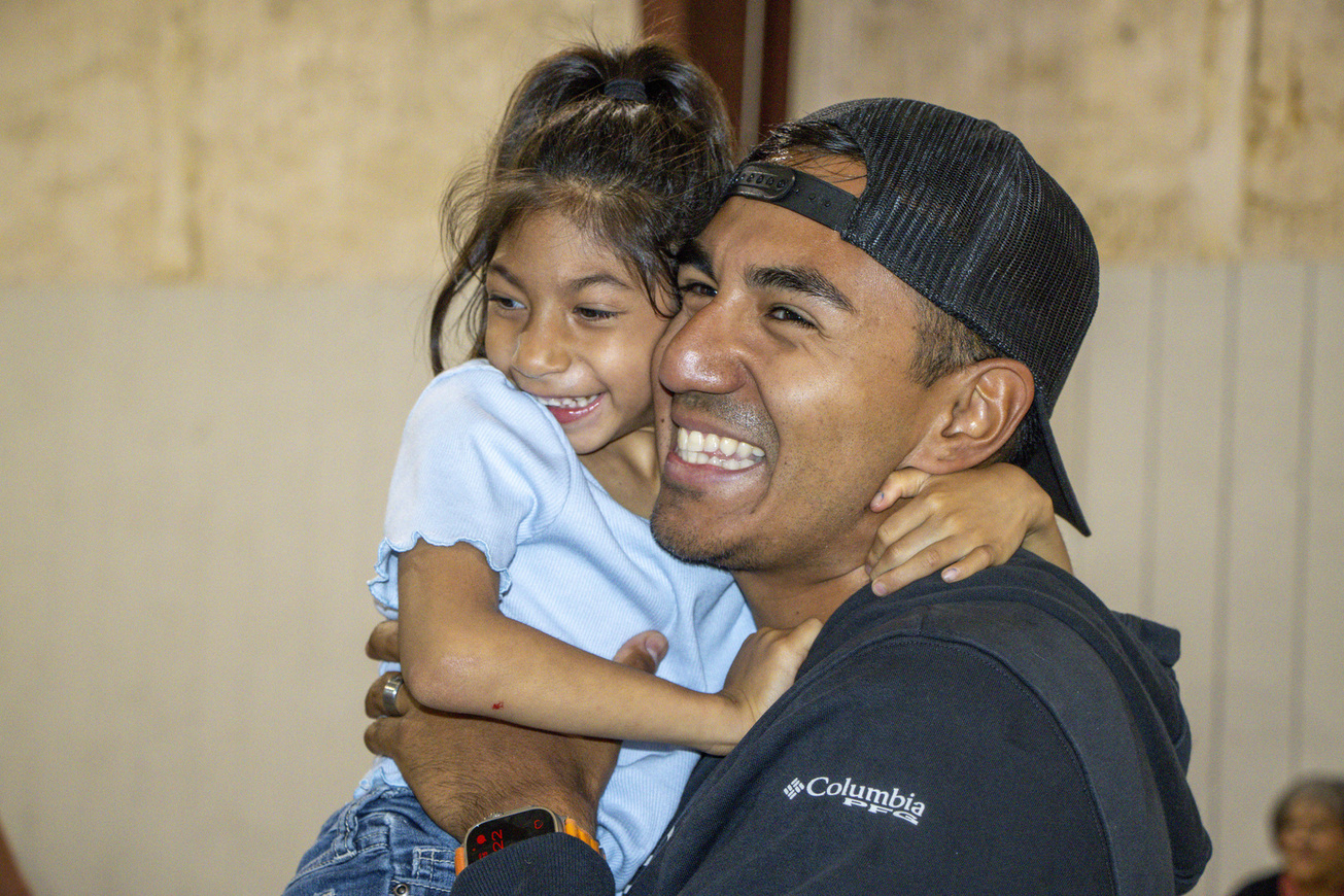 Alexus carrying Bella, both smiling joyfully.