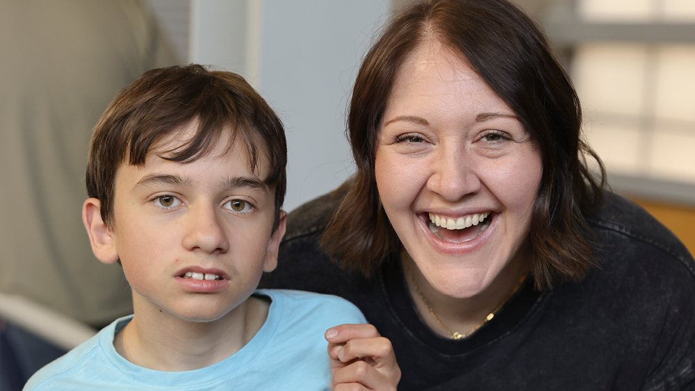 A boy and his mother pose for a photo