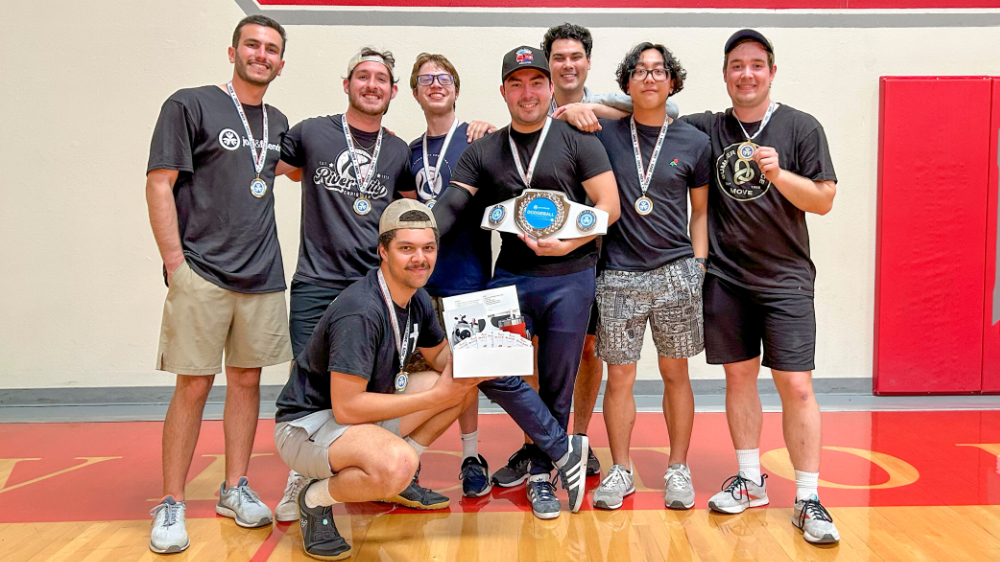 A dodgeball team shows off their medals and awards