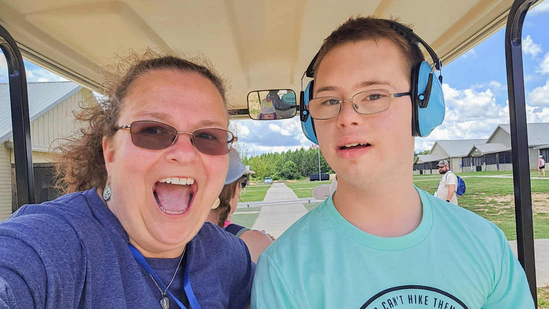 A camper and volutneer pose for a photo at Family Retreat