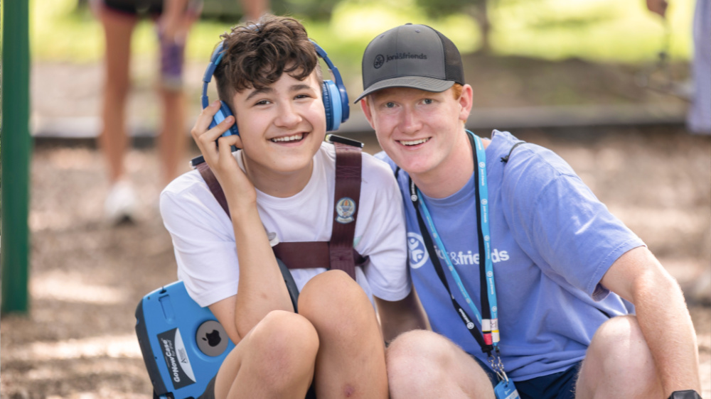 A camper and volunteer pose for a photo at Family Retreat