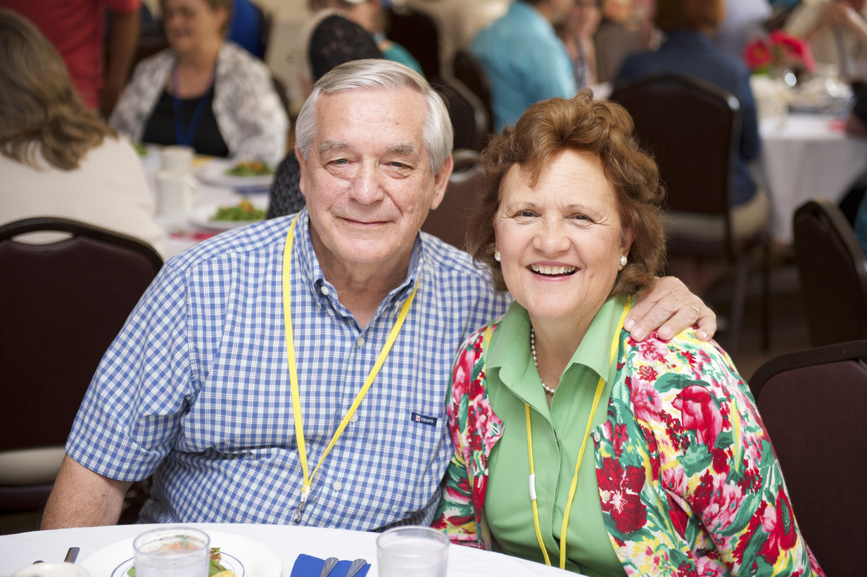 Butch and Nancy sitting in front of a table, smiling at the camera.
