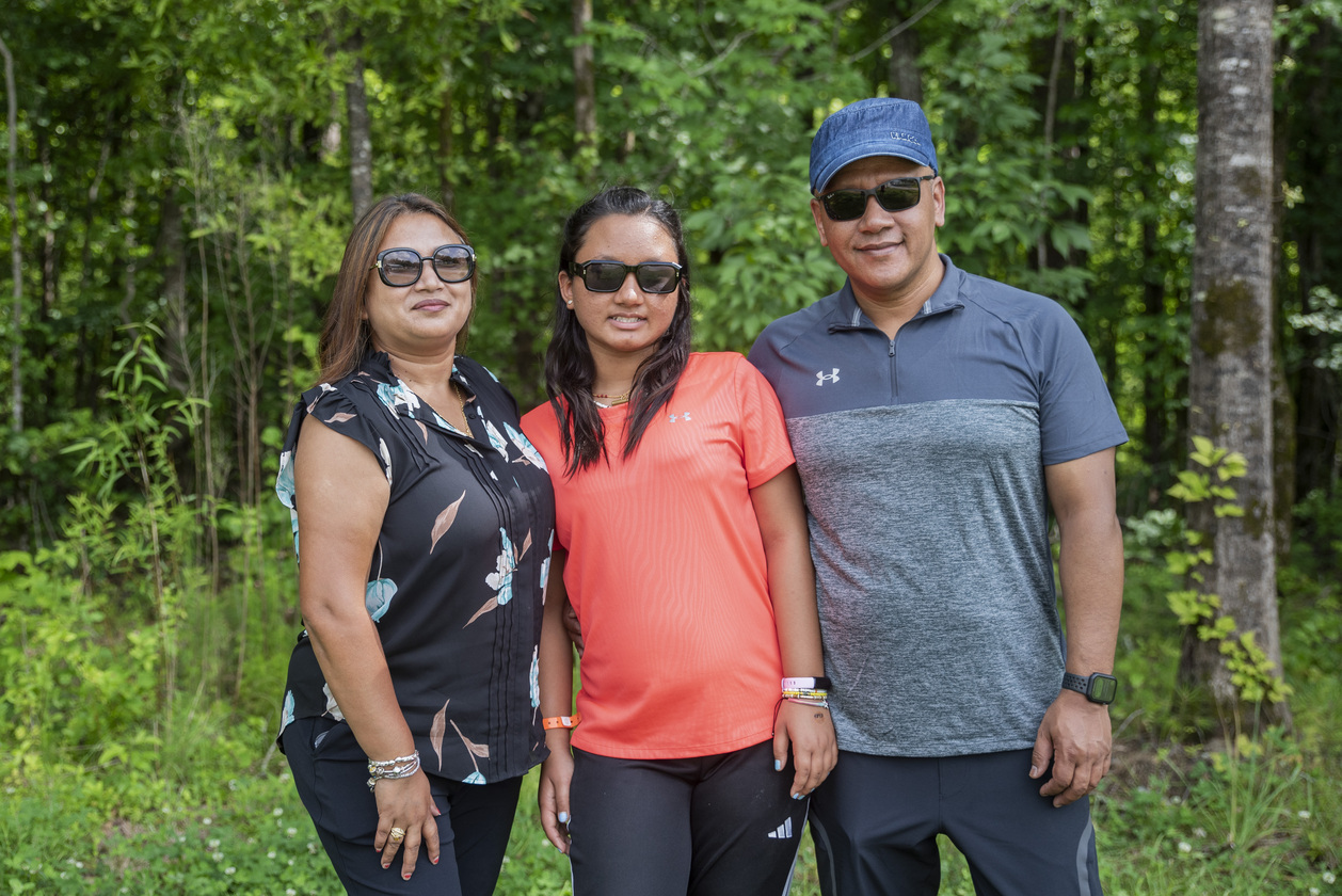 Aruna and her husband pose with their daughter Sana for a family picture.