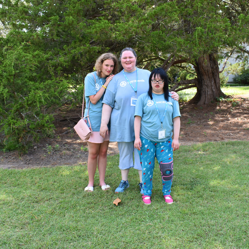 Jennifer stands on the grass with her two daughters, Maddie and Yan. All three are wearing their Joni and Friends T-shirts.