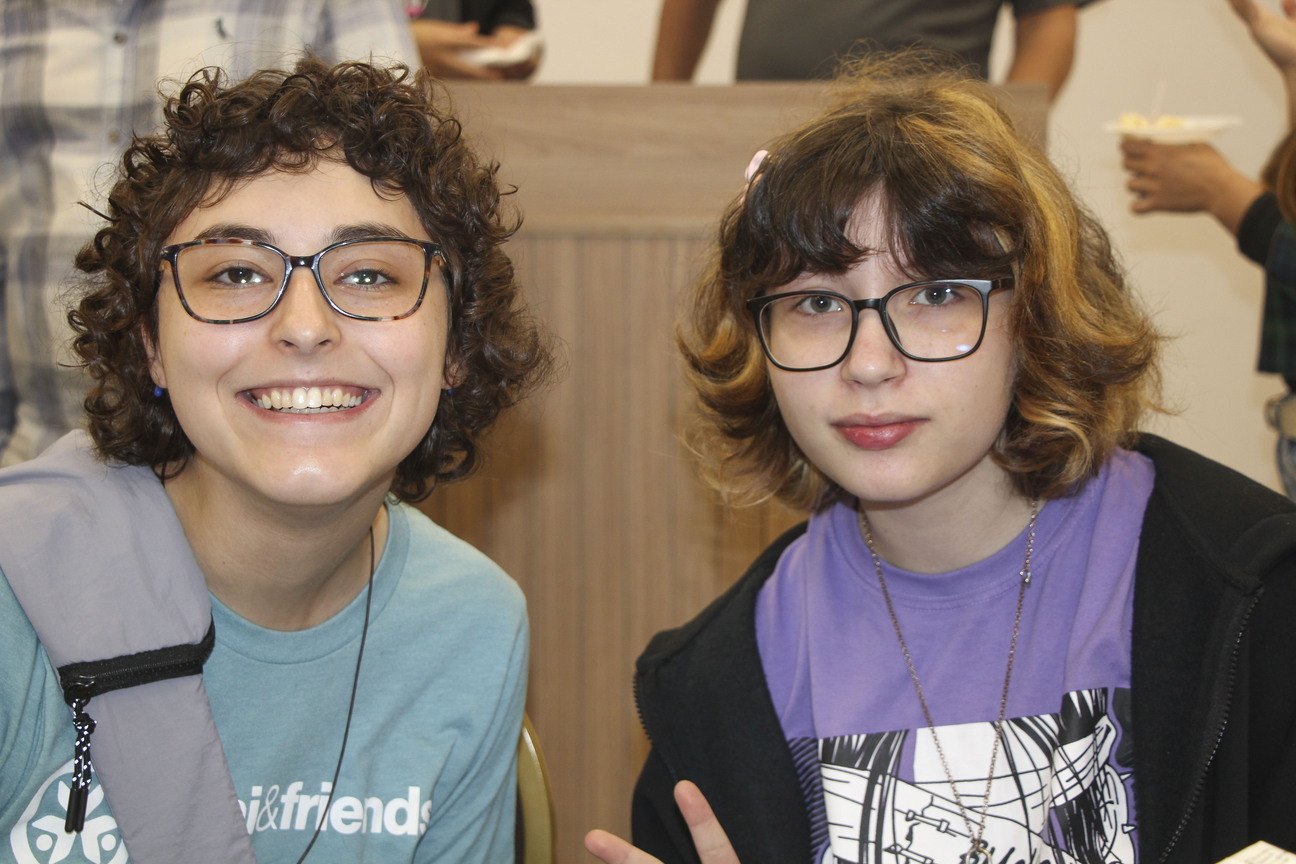 Amelia standing next to another woman, both looking at and smiling at the camera.