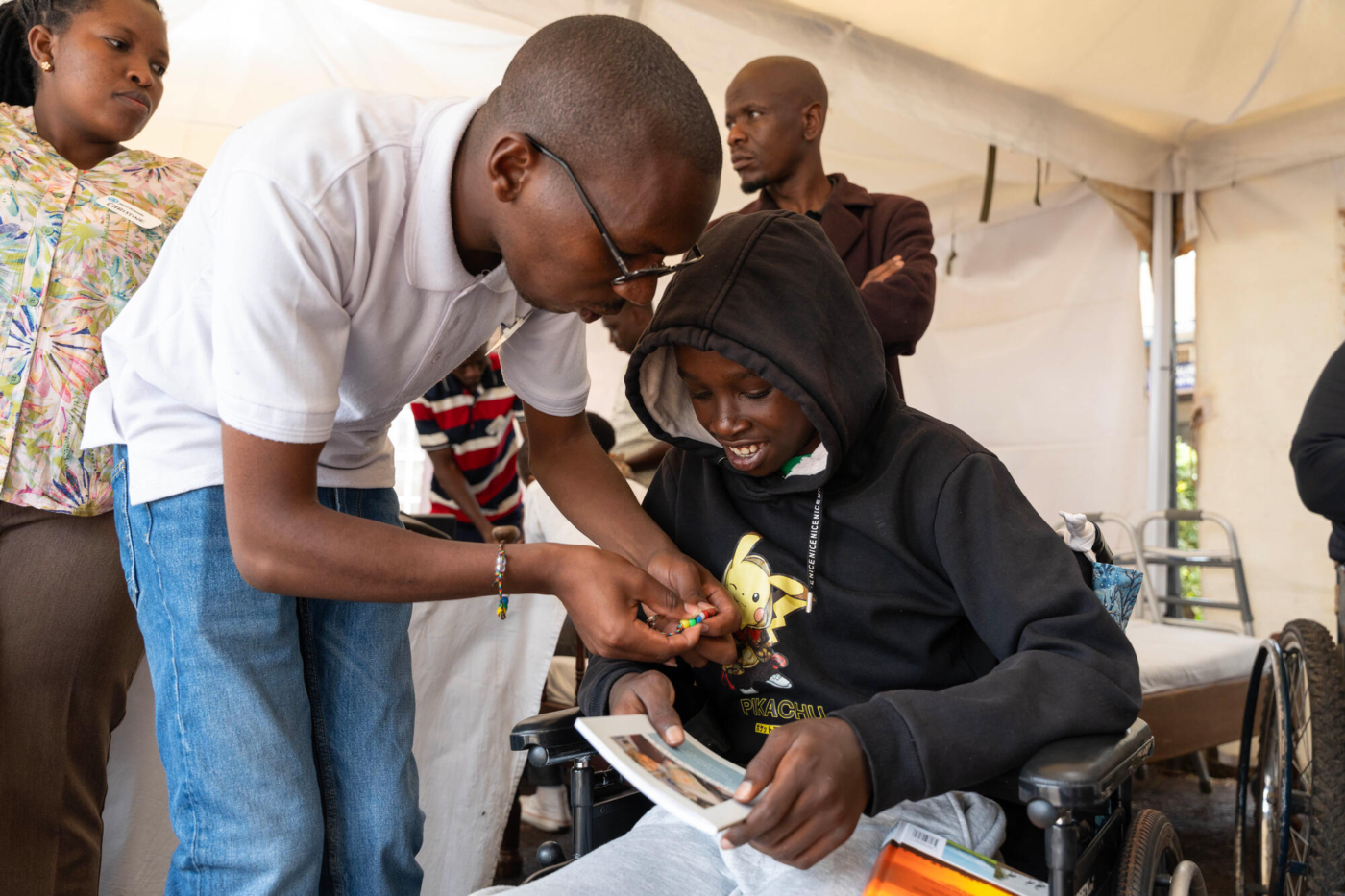 Kelvin shares the Gospel using colored bead bracelets with a young boy who just received his new wheelchair.