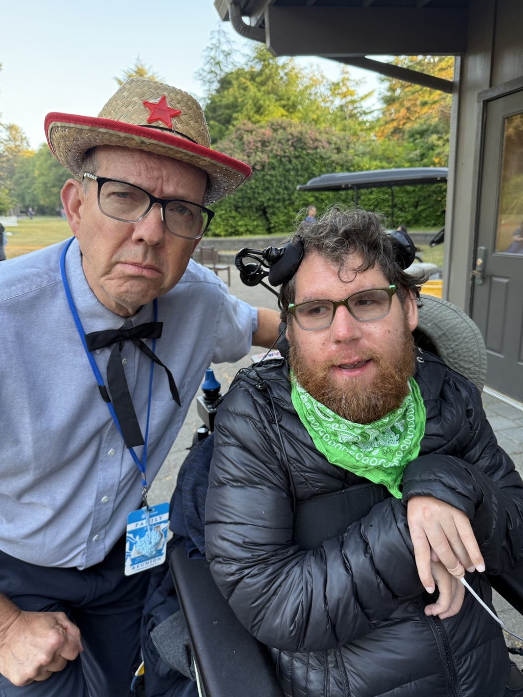 Alex in his power wheelchair next to his buddy volunteer at Family Retreat.