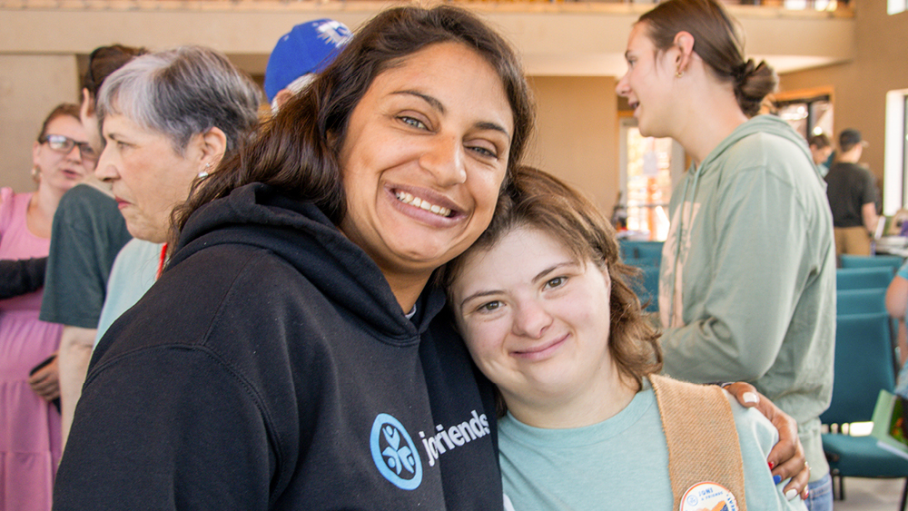 A camper and volunteer pose for a photo