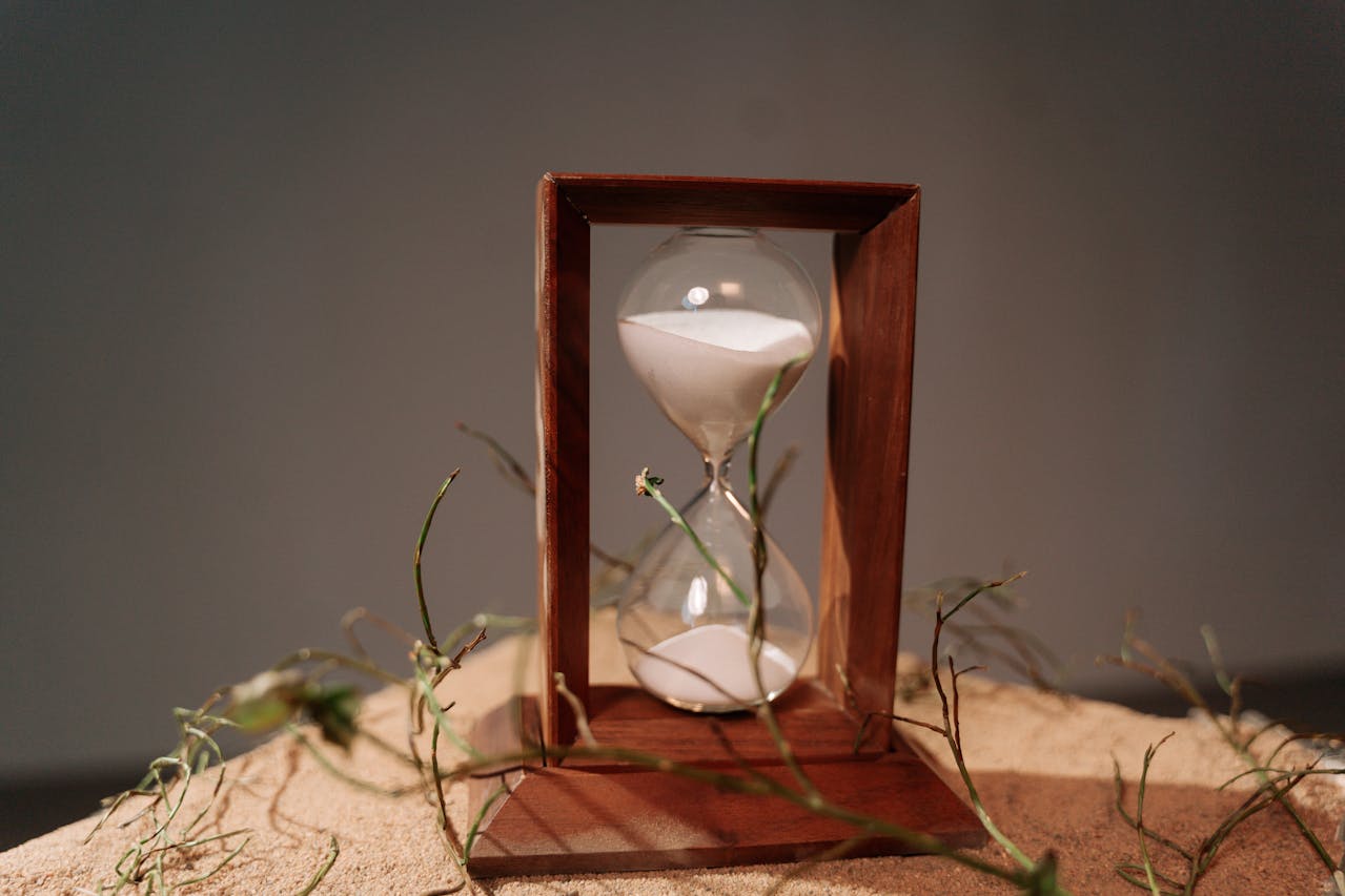 An hourglass with sand flowing through it.