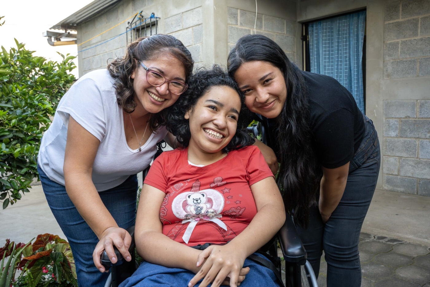 Debbie, Memita, and another woman smile and pose for the camera.
