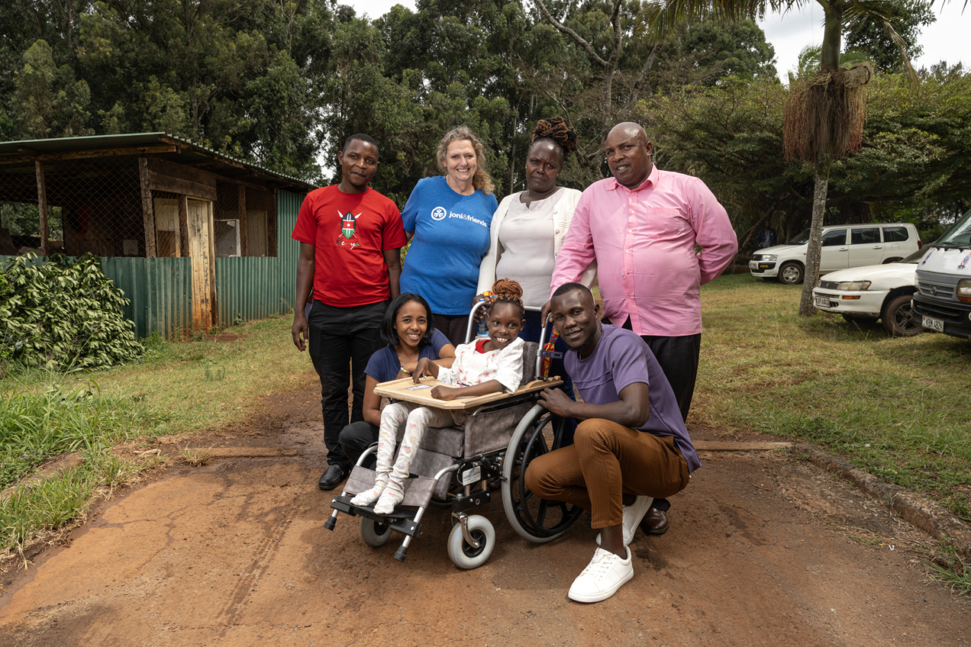 Praise sits in her wheelchair, surrounded by staff from Joni and Friends.
