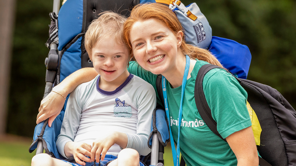 A camper and volunteer pose for a photo at Family Retreat