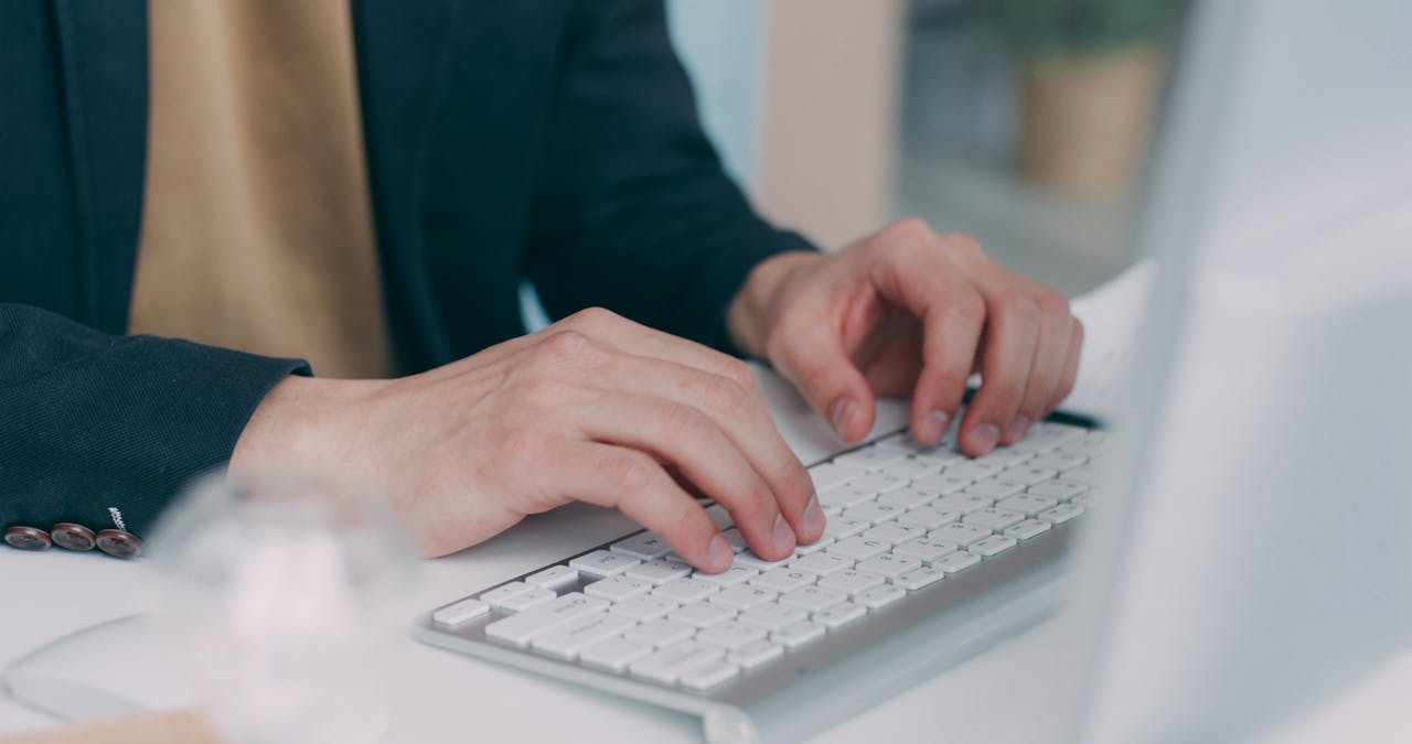 Close-up of hands typing on a laptop keyboard