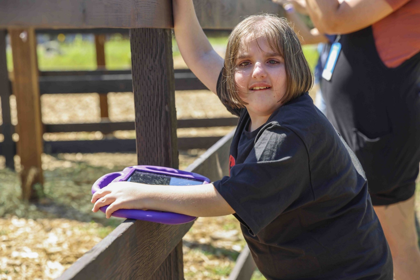 Andi smiling at the camera while holding her iPad.