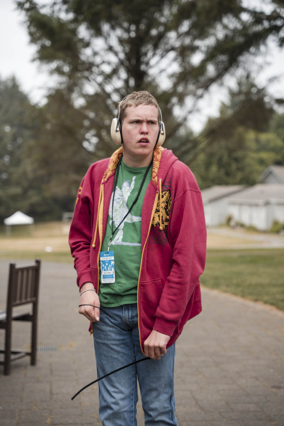 Simon standing and looking off to the side while wearing headphones.