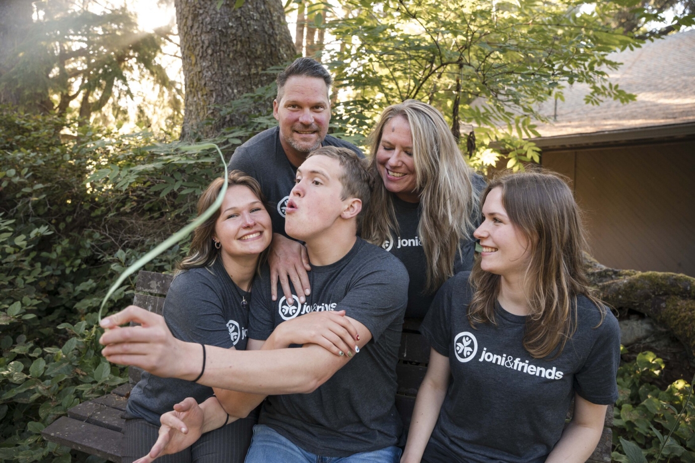 Raelene, Dan, Simon, Sydney, and McKenzie laughing together in a candid family photo, having fun and enjoying the moment.