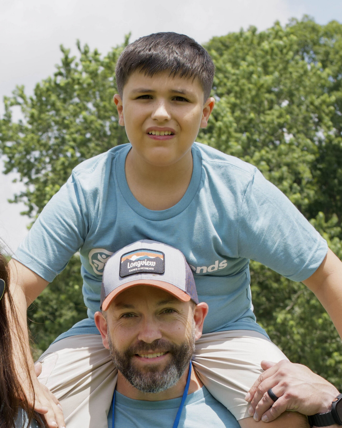 Jayson carrying his son Collier on his shoulders, both smiling at the camera.