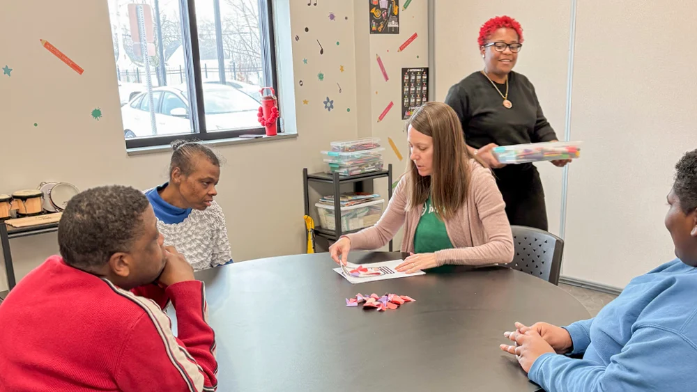 A group of people sit around a table doing an activity