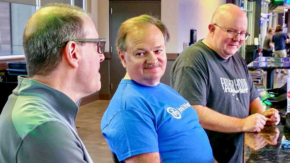 Three men talking at a Joni and Friends events