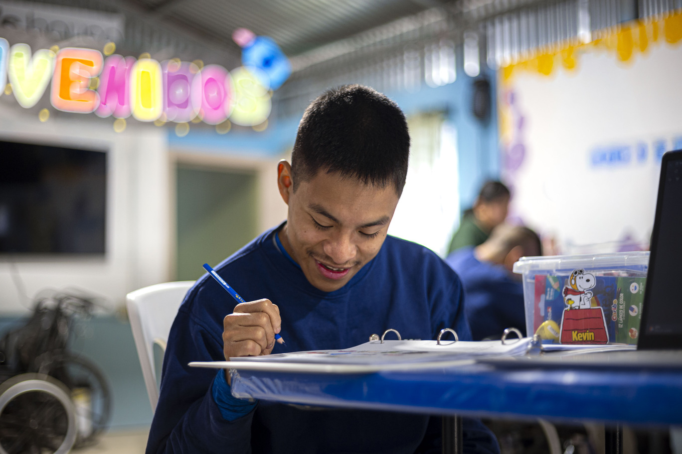 Kevin holding a color pencil while focusing on his coloring.