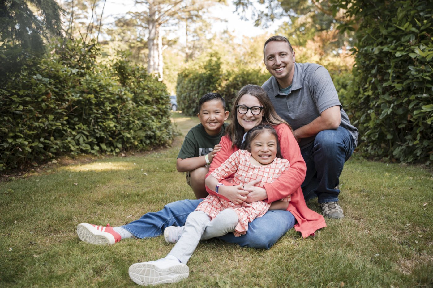 Molly, Justin, Isla, and Zeke on the grass, smiling and posing for the camera.