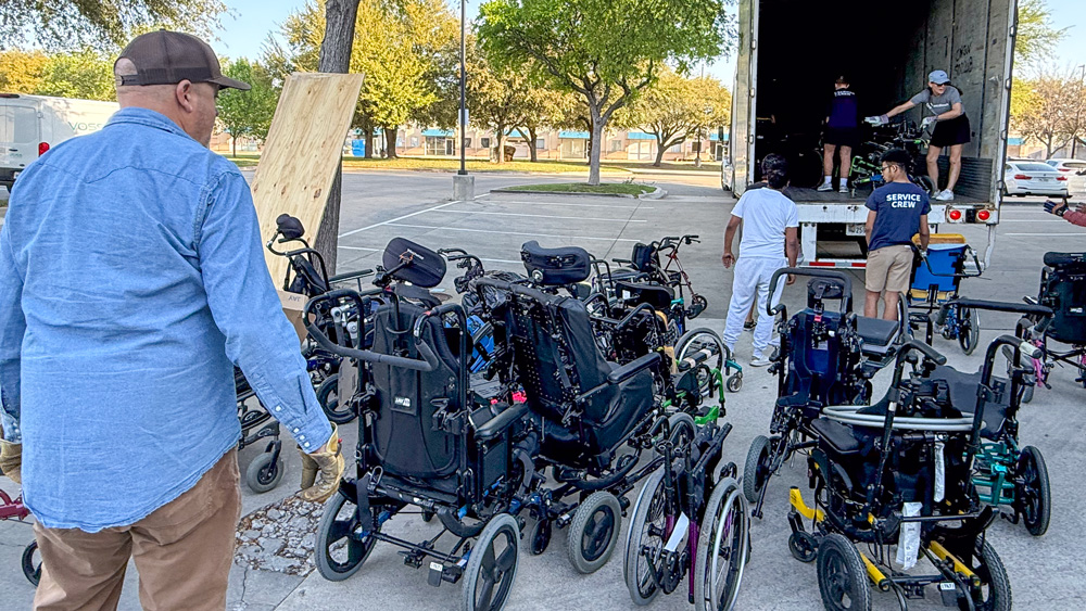 People load wheelchairs into a truck at a Joni and Friends Wheelchair Collection event