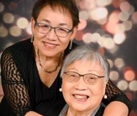 A woman with her mom. Both are smiling for the camera.