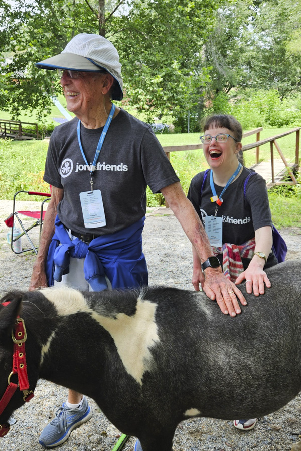 Ron and Jenny hold a black-and-white pony while enjoying the experience.