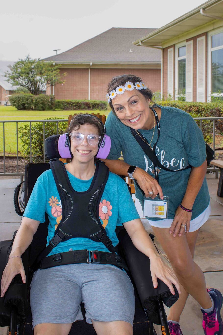 Bailey smiles while sitting in a wheelchair next to another woman.