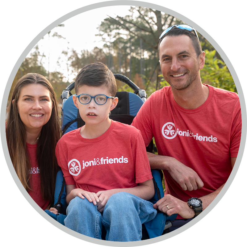 A family in red Joni and Friends t-shirts pose for a photo at Family Retreat.