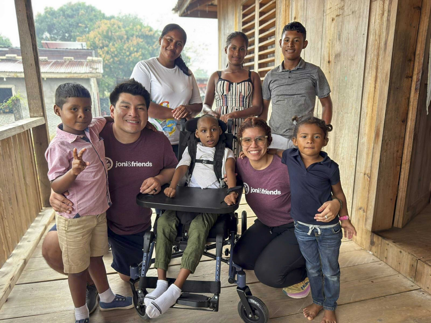 A group poses with a boy who has received a new wheelchair.