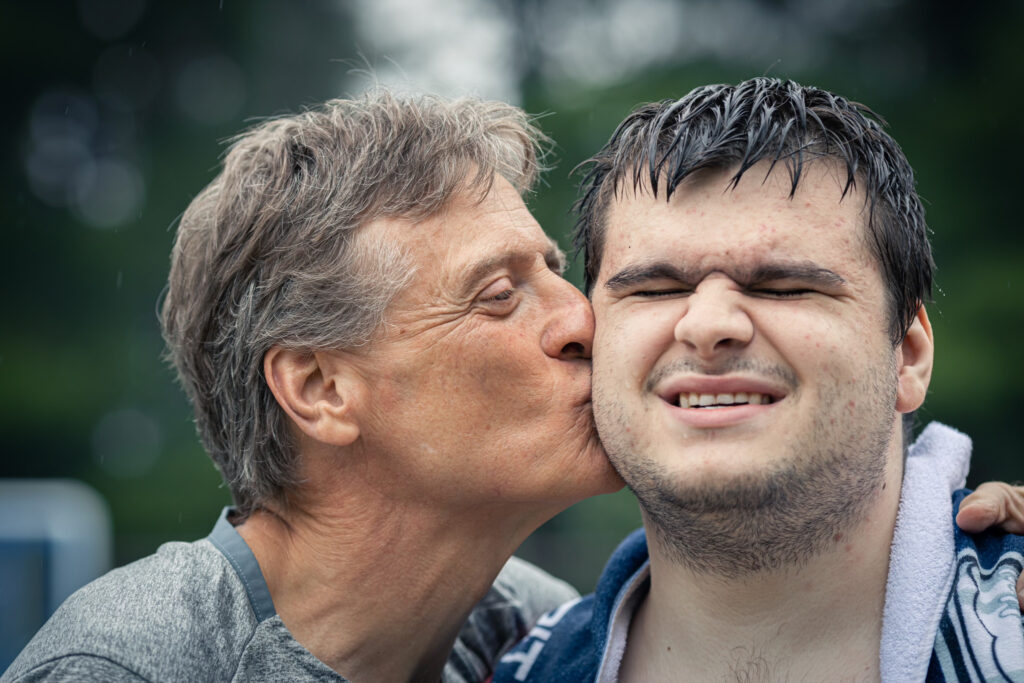 Tom Stolle kisses his son, Jimmy, on the cheek.
