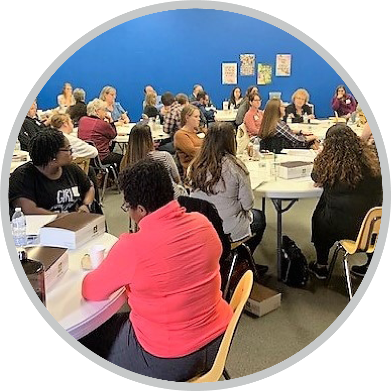 People sitting at round tables listening attentively.