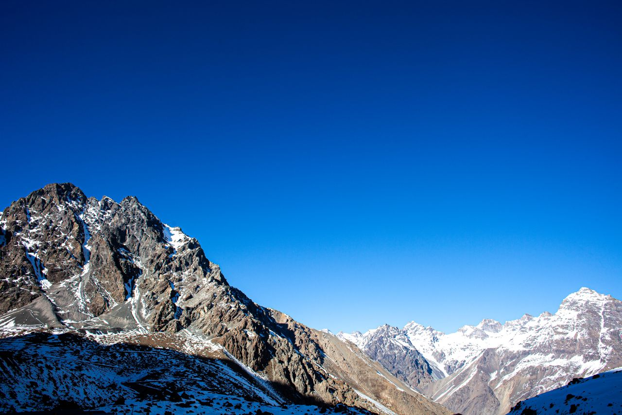 Stunning view of rugged snow-capped mountains with clear blue sky in the Andes.