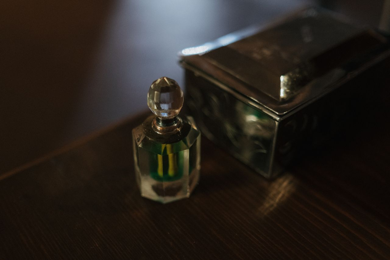 Elegant crystal perfume bottle next to a silver box, evoking a classic and timeless atmosphere.