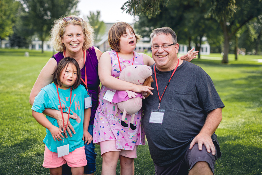 A family photo of Patricia, Hugh, Bethany, and Lily posing together outdoors.