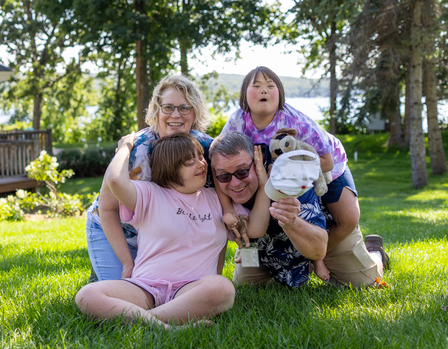 Hugh and Patricia with their two daughters, Bethany and Lily, sharing a happy moment outdoors.