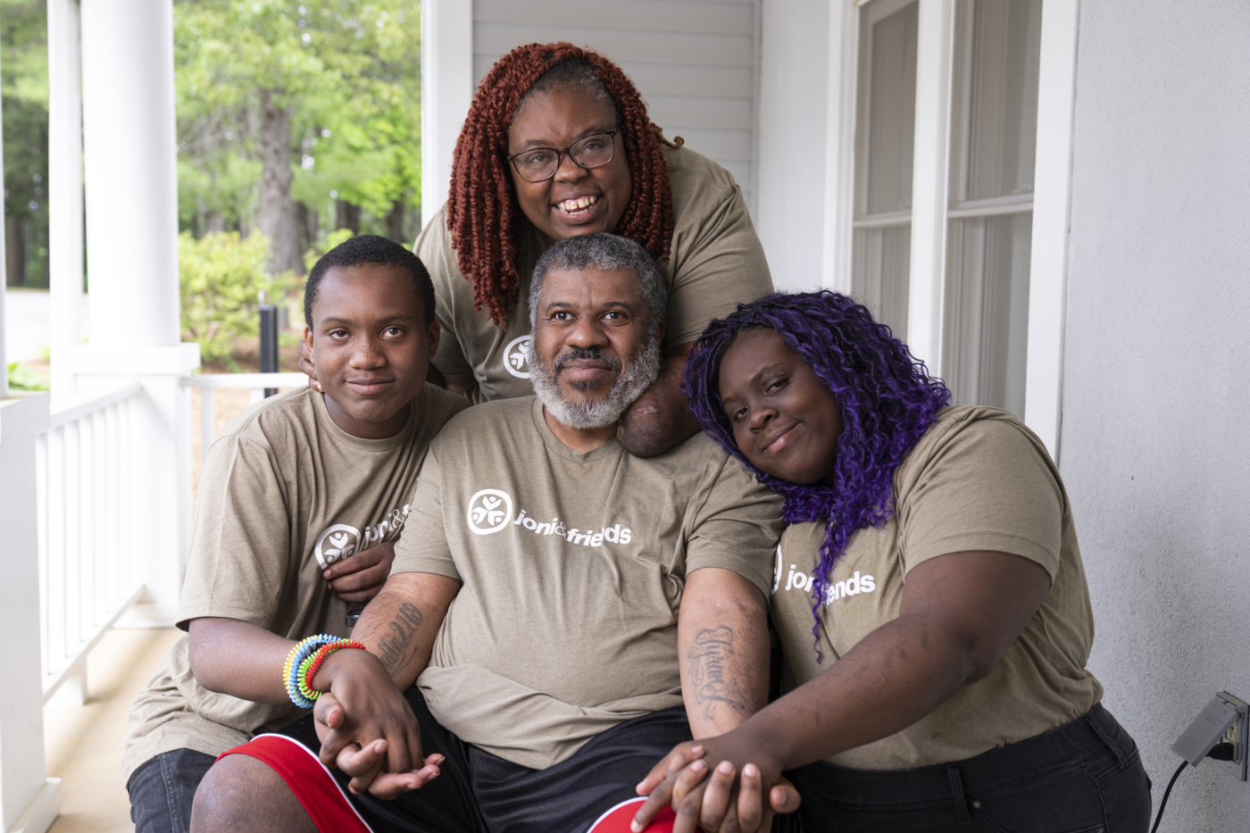Natacha with her husband, daughter, and son, all smiling and posing for the camera.