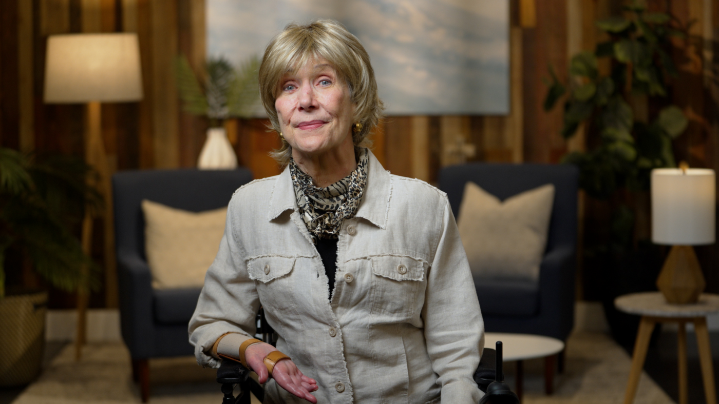Joni Eareckson Tada smiling at the camera in a cozy living room.