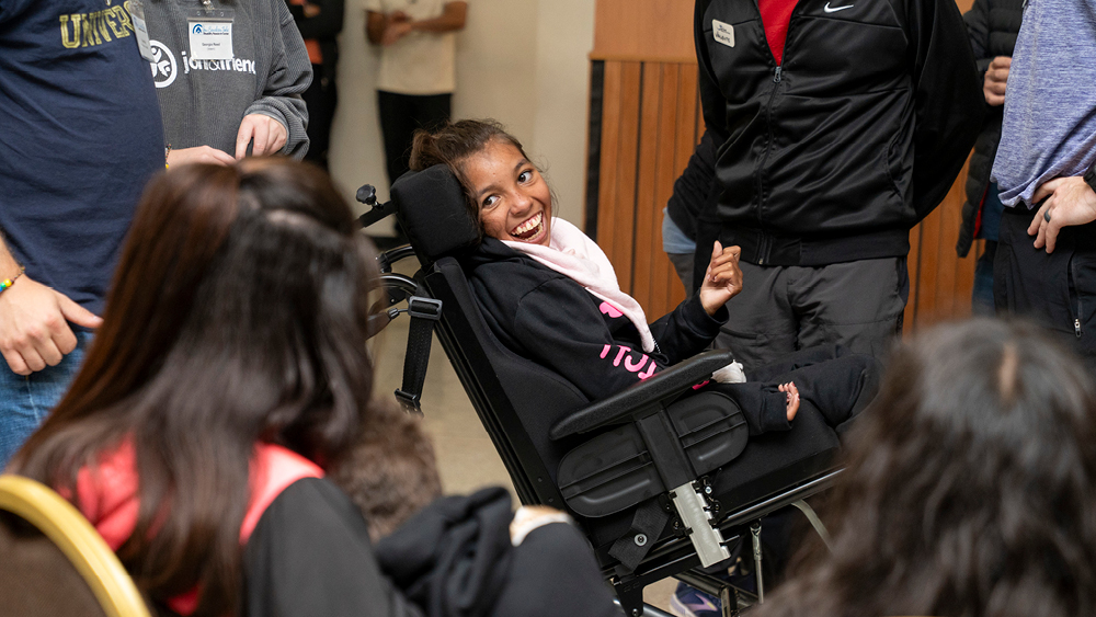 A girl smiles in her new wheelchair